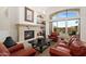 Comfortable living room with a stone fireplace, built-in shelves, and views of the outdoor pool area at 11187 E De La O Rd, Scottsdale, AZ 85255
