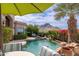 Inviting pool area with a natural rock waterfall and vibrant flowering shrubbery with mountain views at 11187 E De La O Rd, Scottsdale, AZ 85255