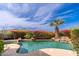 Backyard pool with beautiful floral landscaping and a rock waterfall feature; set against mountain views at 11187 E De La O Rd, Scottsdale, AZ 85255