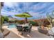 Outdoor dining set with umbrella and patio with fire pit showcasing mountain views, perfect for entertaining at 11187 E De La O Rd, Scottsdale, AZ 85255