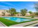 Beautifully landscaped backyard with a modern pool, green turf accents, desert landscaping, and mature shade trees at 11649 N Miller Rd, Scottsdale, AZ 85260