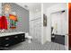 Modern bathroom with a geometric patterned wall, black vanity, and patterned tile floors at 11649 N Miller Rd, Scottsdale, AZ 85260