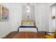 Bright bedroom with hardwood floors, a cozy bed, and minimalist decor at 11649 N Miller Rd, Scottsdale, AZ 85260