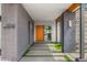 Contemporary home exterior featuring a brick facade, a vibrant orange door, and attractive landscaping at 11649 N Miller Rd, Scottsdale, AZ 85260