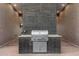 Outdoor cooking area with built-in stainless steel grill and brick accents at 11649 N Miller Rd, Scottsdale, AZ 85260