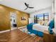 Spacious bedroom with a geometric accent wall, hardwood floors, and a view to the outdoor landscape at 11649 N Miller Rd, Scottsdale, AZ 85260