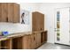 A mudroom with custom wood cabinets, granite counters, and a door leading to the outdoor pool at 11649 N Miller Rd, Scottsdale, AZ 85260