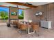 Covered outdoor dining area with brick accents, a built-in bar, and a large wooden table with seating for eight at 11649 N Miller Rd, Scottsdale, AZ 85260
