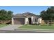 Charming single-story home featuring a two-car garage and inviting front yard with fresh landscaping at 12427 E Wallflower Ln, Florence, AZ 85132