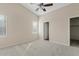 Spacious bedroom with neutral walls, carpet flooring, a ceiling fan, and an adjacent closet at 16585 W Tonto St, Goodyear, AZ 85338