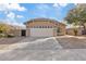 Exterior view of a two-car garage with a neutral-colored exterior and well-maintained landscaping at 16585 W Tonto St, Goodyear, AZ 85338