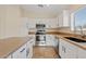 Modern kitchen with stainless steel appliances, white cabinets, and granite countertops at 16585 W Tonto St, Goodyear, AZ 85338