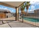 Covered patio with metal fencing offers views of the swimming pool and beautiful palm trees at 16585 W Tonto St, Goodyear, AZ 85338