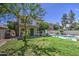 Backyard with lush green lawn, mature trees and pool at 1720 W Orchid Ln, Chandler, AZ 85224