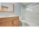 Bathroom with wood vanity, and shower over tub with white tile surround and glass doors at 1720 W Orchid Ln, Chandler, AZ 85224