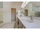 Well-lit bathroom with double sinks, a large mirror, and neutral decor at 1720 W Orchid Ln, Chandler, AZ 85224