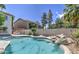 Sparkling backyard pool with rock waterfall feature and mature landscaping at 1720 W Orchid Ln, Chandler, AZ 85224