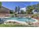 Backyard pool with waterfall, rock features, mature trees, and grass at 1720 W Orchid Ln, Chandler, AZ 85224