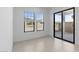 Bright room featuring neutral tile flooring, white walls, large windows and a sliding door at 20308 W Montecito Ave, Buckeye, AZ 85396