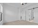 Spacious bedroom featuring bright walls, carpet flooring, a barn door, and ensuite bathroom at 20308 W Montecito Ave, Buckeye, AZ 85396