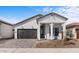 Charming single-story home with modern farmhouse design, paver driveway and dark garage door at 20308 W Montecito Ave, Buckeye, AZ 85396