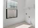 Bright laundry room with a window, neutral tile flooring, and washer/dryer hookups at 20308 W Montecito Ave, Buckeye, AZ 85396