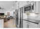 Modern kitchen with stainless steel appliances and white cabinetry adjacent to a living area at 21325 S 201St Way, Queen Creek, AZ 85142