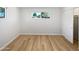 Minimalist bedroom design with light wood flooring, closet and a sunlit window view at 2201 W Avalon Dr, Phoenix, AZ 85015