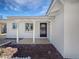 Inviting front porch with white columns, a dark door, and well-manicured landscaping elements at 2201 W Avalon Dr, Phoenix, AZ 85015