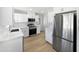 Modern kitchen with stainless steel appliances, white cabinets, quartz countertops, and wood-look floors at 2201 W Avalon Dr, Phoenix, AZ 85015
