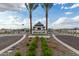 Landscaped community entrance with stone signage, decorative foliage, and palm trees at 2522 E Presidio St, Mesa, AZ 85213