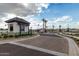 Community entry featuring a guard house, stone pillars, lush landscaping, and decorative street lighting at 2522 E Presidio St, Mesa, AZ 85213