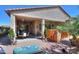 Well-manicured backyard featuring a hot tub, covered patio, pavers, and desert landscaping at 2623 E Marcos Dr, Casa Grande, AZ 85194