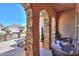 Covered patio with stone arches, outdoor seating, and view of the landscaped courtyard at 2623 E Marcos Dr, Casa Grande, AZ 85194