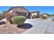 Landscaped home exterior with a paved driveway, desert landscaping, and plants at 2623 E Marcos Dr, Casa Grande, AZ 85194