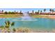 Community pond with a fountain, surrounded by a golf course and palm trees at 2623 E Marcos Dr, Casa Grande, AZ 85194