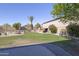 Expansive backyard with green grass, mature trees, and outdoor decor offers plenty of space to enjoy at 31918 N Caspian Way, San Tan Valley, AZ 85143