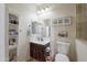 Bathroom with decorative shelves, vanity, and a toilet against light beige walls at 31918 N Caspian Way, San Tan Valley, AZ 85143