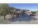 Stately home exhibits a lush front yard, covered porch, and sizable driveway leading to a two-car garage at 31918 N Caspian Way, San Tan Valley, AZ 85143