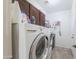 Functional laundry room featuring tile flooring, upper cabinets, and modern, front loading washer and dryer at 31918 N Caspian Way, San Tan Valley, AZ 85143
