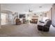 Spacious living room with neutral carpet, comfortable seating, and natural light filtering through large windows at 31918 N Caspian Way, San Tan Valley, AZ 85143