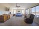 Expansive main bedroom features plush carpet, large windows, a ceiling fan, and a comfortable seating area at 31918 N Caspian Way, San Tan Valley, AZ 85143