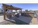 Covered outdoor patio area with comfortable seating, outdoor kitchen features, a fire pit, and RV parking at 31918 N Caspian Way, San Tan Valley, AZ 85143