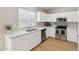 Well-lit kitchen with stainless appliances, white cabinets, quartz countertops, and stylish fixtures at 3321 N Silverado --, Mesa, AZ 85215
