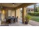 Covered patio with stone columns and fan, outdoor dining set with views of green lawn at 3911 E Rockingham Rd, Phoenix, AZ 85050