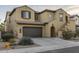 Two-story tan stucco home showcasing a brown garage door and charming architectural details at 3911 E Rockingham Rd, Phoenix, AZ 85050