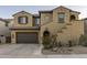 Charming two-story home showcasing a brown two-car garage and beautiful desert landscaping at 3911 E Rockingham Rd, Phoenix, AZ 85050