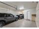 Spacious garage with epoxy flooring, storage cabinets, and two parked cars at 3911 E Rockingham Rd, Phoenix, AZ 85050