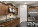 Close-up of a kitchen featuring dark wood cabinets, stainless steel appliances, and granite countertops at 3911 E Rockingham Rd, Phoenix, AZ 85050