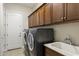 Functional laundry room featuring dark wood cabinets and modern machines at 3911 E Rockingham Rd, Phoenix, AZ 85050